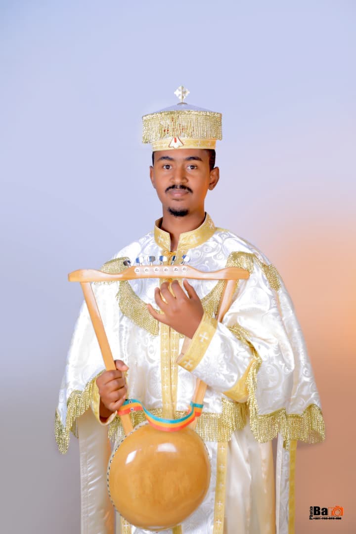 Decon BirhaneMeskel, Chief Instructor, Tebiban School, in ceremonial vestments holding a traditional Ethiopian lyre